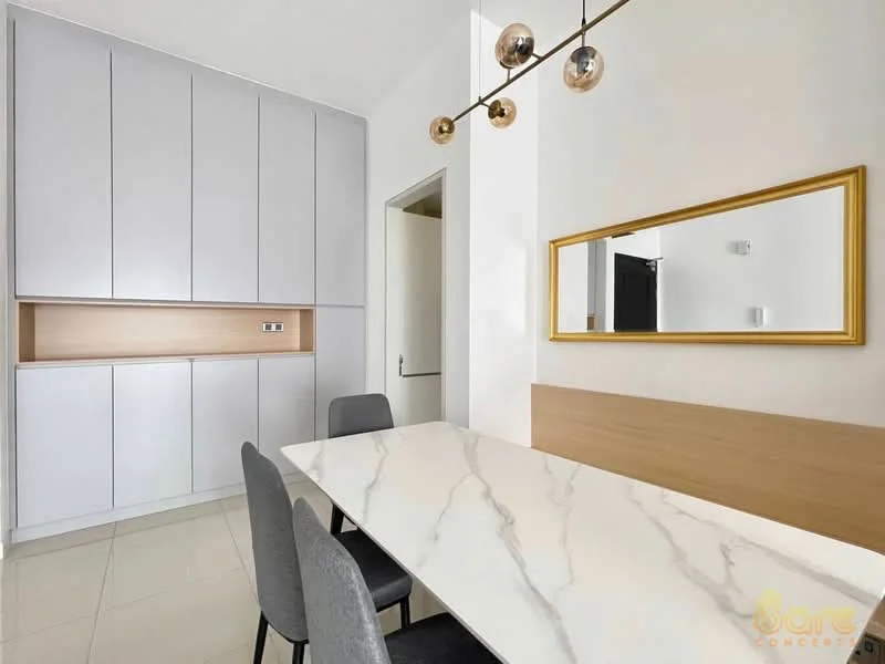 Dining features: marble dining table, 4 upholstered dining chairs in grey, white walls, grey cabinetry with wood accents, recessed downlights, gold-framed mirror, tile flooring, open layout; style: modern.