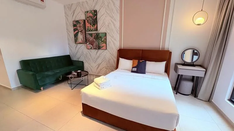 Bedroom features: queen-size bed with brown upholstered headboard, white bedding with decorative throw pillow, green fabric sofa, black coffee table, round mirror on white side table, wall art with tropical theme, light fixture with pendant design, beige accent wall, light-colored tile flooring, curtains in neutral color, air conditioning unit on wall; style: modern.