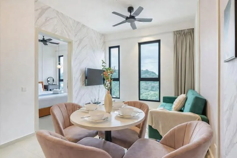 Dining features: round dining table, 4 upholstered dining chairs in pink, vase with flowers on table, white walls, light-colored flooring, ceiling fan, wall-mounted TV, floor-to-ceiling windows, curtains, green sofa, decorative wall art; style: modern; view: mountain.