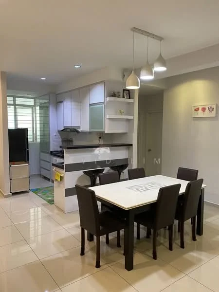 Dining features: 6-seater dining table with white top, black dining chairs, pendant lighting above table, white walls, glossy tile flooring, green area rug, decorative wall art, open layout to kitchen; style: modern. Kitchen features: white cabinetry with glass panels, black countertop, stainless-steel sink, built-in oven, freestanding fridge, ceramic tile backsplash, kitchen island with seating, window for natural light; style: modern.