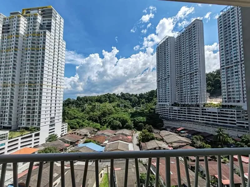 Exterior type: high-rise condominium; features: surrounded by mature greenery, city skyline view, multiple high-rise buildings, residential area with low-rise houses, clear blue sky, clouds, balcony railing visible; style: modern.