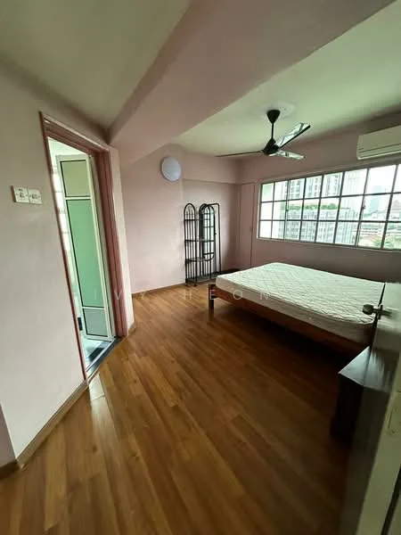 Bedroom features: wooden flooring, pink painted walls, 5-blade ceiling fan, floor-to-ceiling windows, window treatments not visible, air conditioning unit, bed frame without mattress, decorative room divider.