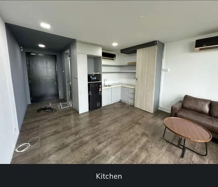 Kitchen features: white cabinetry, grey countertops, stainless-steel sink, built-in microwave, freestanding fridge, 2-burner electric hob, exposed ductwork, laminate flooring, recessed downlights, wall-mounted split AC; style: modern. Living features: brown leather sofa, round coffee table, laminate flooring, wall-mounted split AC, neutral wall color, open layout; style: modern.