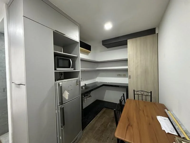 Kitchen features: grey cabinetry, black countertop, stainless-steel fridge, built-in microwave, single-bowl stainless-steel sink, chrome pull-down faucet, wall-mounted shelves, wood dining table, metal dining chairs, laminate flooring, recessed downlights, white painted walls; style: modern.