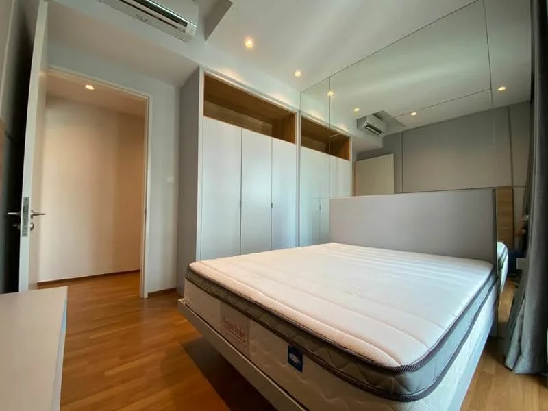 Bedroom features: queen-size bed, built-in wardrobe with sliding doors, wooden flooring, mirror wall, recessed downlights, wall-mounted split AC, neutral wall colour, curtains, nightstand, door leading to hallway; style: modern.