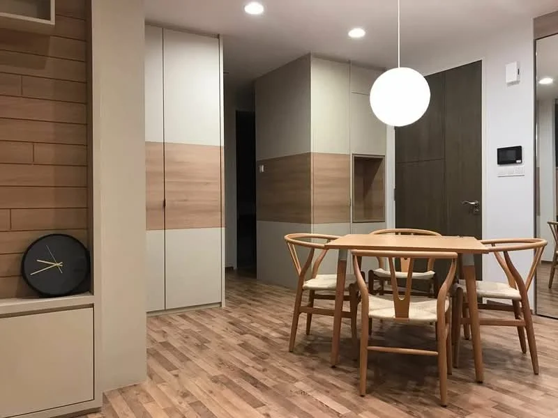 Dining features: wooden dining table, 4 wooden dining chairs, pendant light fixture, light wood flooring, wall-mounted clock, built-in cabinetry with wood accents, neutral wall color, mirrored wall section; style: modern.