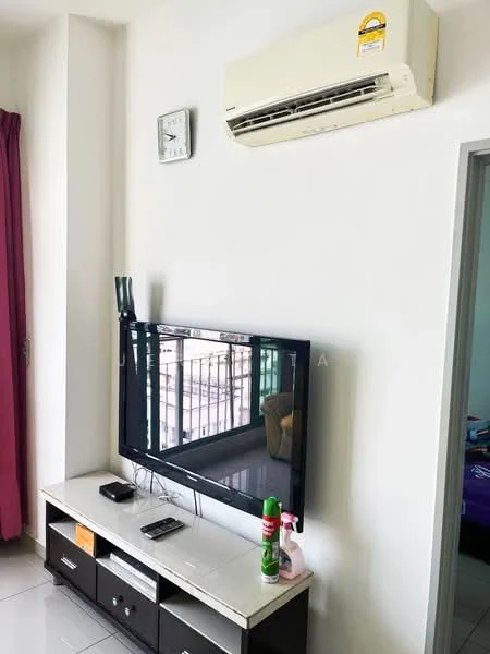 Living features: wall-mounted TV, TV console with drawers, white painted walls, grey tiled flooring, 1 wall-mounted split AC, clock on wall, purple curtains, cleaning supplies on console; style: modern.