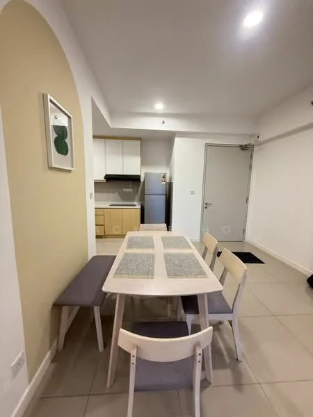 Dining features: rectangular dining table with light wood finish, 4 dining chairs with light wood frame and grey cushions, cream painted walls, tile flooring, recessed ceiling lights, open layout to kitchen, fridge visible in background, kitchen cabinetry visible in background; style: modern.