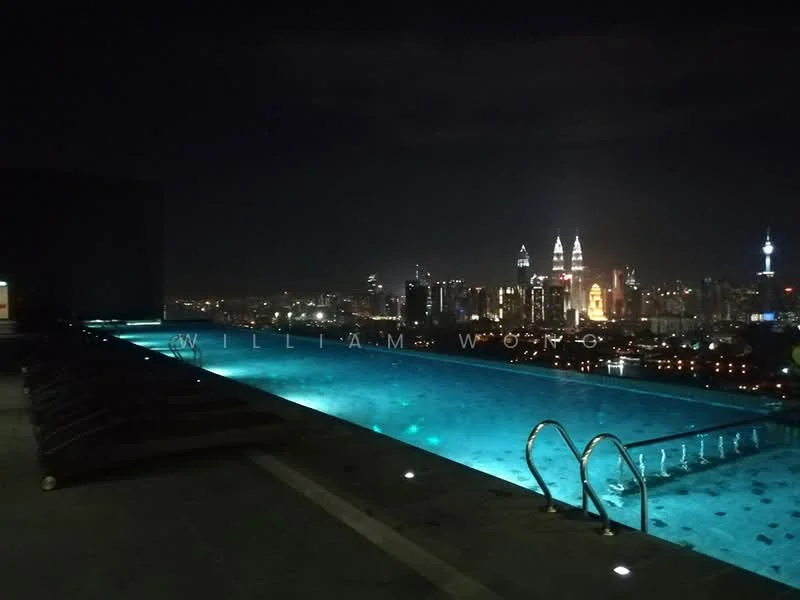 Exterior type: high-rise condominium; features: infinity pool, pool deck with loungers, city skyline view, night lighting, glass railing, tile flooring around pool; style: modern.