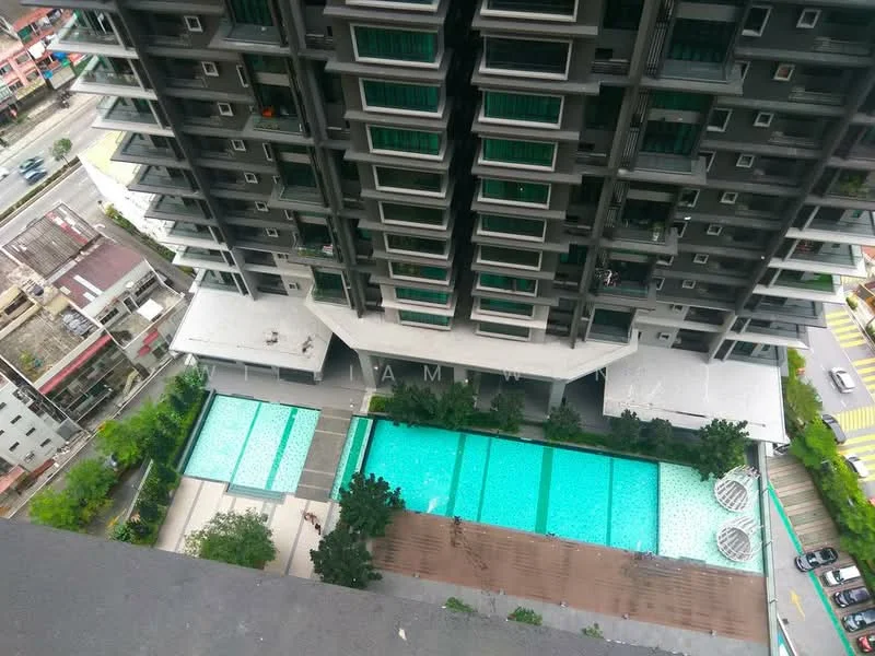 Exterior type: high-rise condominium; features: multiple swimming pools, pool deck with loungers, landscaped garden area, surrounding greenery, modern architectural design, balconies on upper floors, glass facade, pedestrian pathways, urban context with nearby buildings, street view visible; style: modern.