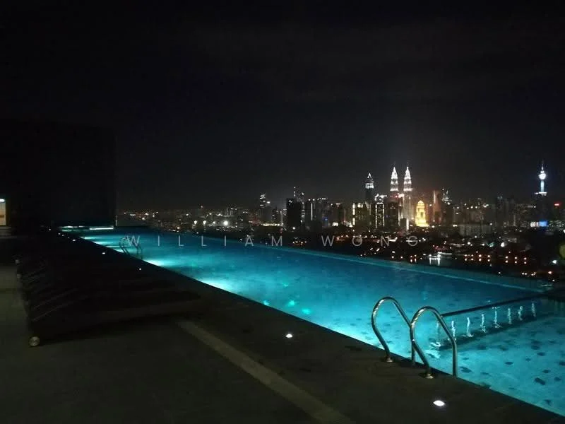 Exterior type: high-rise condominium; features: infinity pool, pool deck with loungers, city skyline view, night lighting, glass railing, tile flooring around pool; style: modern.