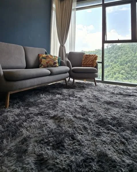 Living features: 3-seater fabric sofa in grey, armchair in grey, decorative throw pillow, area rug with shaggy texture, floor-to-ceiling windows, curtains, mountain view, wooden legs on furniture, accent cushion in orange, painted accent wall in dark blue; style: modern; view: mountain.