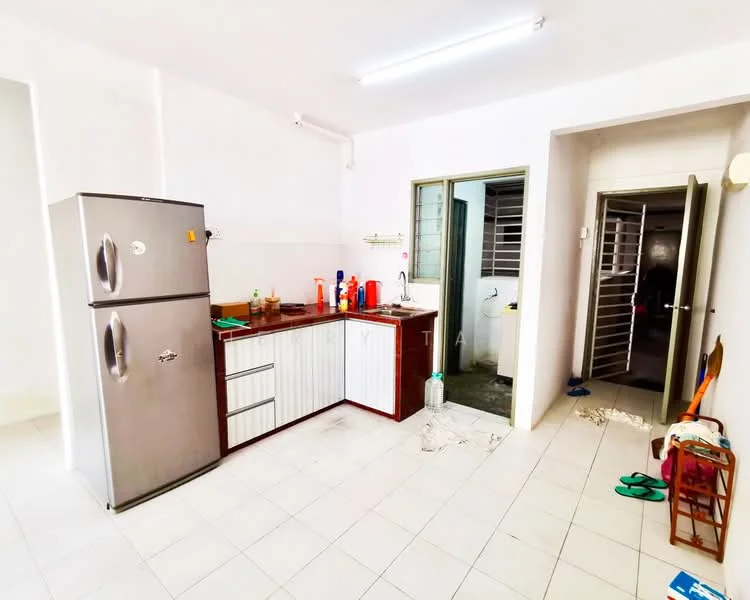 Kitchen features: stainless-steel fridge, wood cabinetry with white and brown finish, single-bowl stainless-steel sink, chrome pull-down faucet, white tiled backsplash, ceramic tile flooring, window with metal grille, countertop space, kitchen utensils and cleaning supplies visible. Room features: door leading to another room, visible plumbing fixtures, floor tiles continue from kitchen.