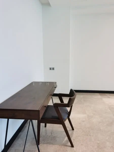 Study features: wooden desk with drawers, black metal legs on desk, upholstered chair with wooden frame, cream painted walls, marble tile flooring, electrical outlets on wall; style: modern.