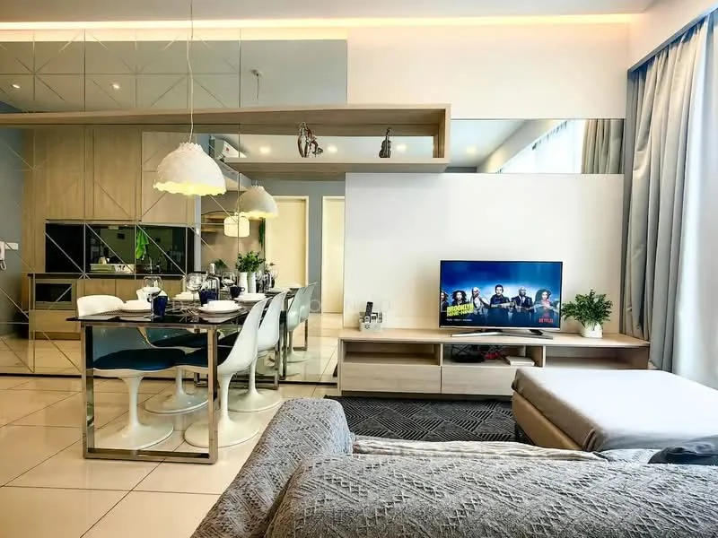Living features: grey upholstered sofa, coffee table, TV console, wall-mounted TV, area rug with geometric pattern, floor-to-ceiling windows with sheer curtains, recessed LED downlights, decorative plants in ceramic pots, mirrored wall, open-plan layout to dining area; style: modern. Dining features: 6-seater dining table, white dining chairs, pendant lighting above the table, decorative table setting, open kitchen area visible, wood cabinetry, black countertop; style: modern.