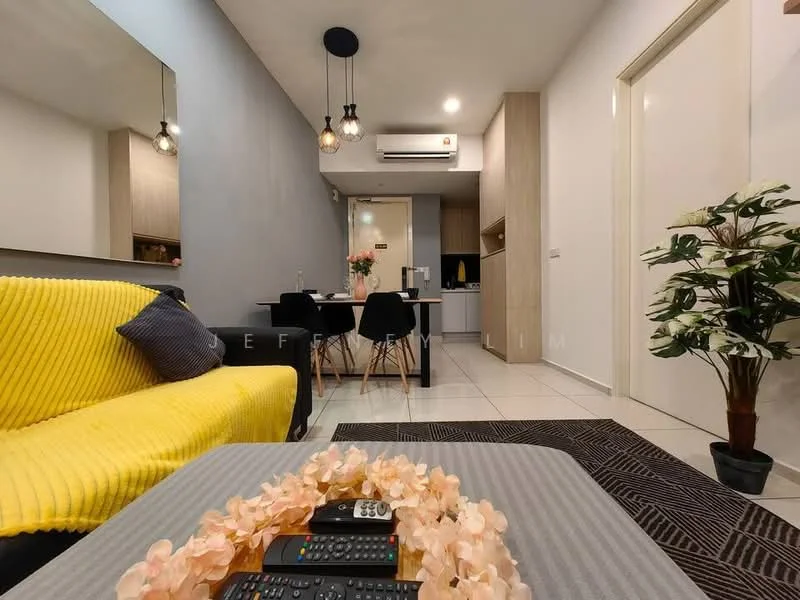 Living features: yellow knitted throw blanket, black accent pillow, 3-seater fabric sofa, coffee table with decorative flowers, remote controls on coffee table, wall-mounted air conditioning unit, recessed ceiling lights, white tiled flooring, grey accent wall, decorative plant in ceramic pot; style: modern. Dining features: 4-seater dining table, black dining chairs, kitchen area visible in background, wooden cabinetry, white countertop; style: modern.
