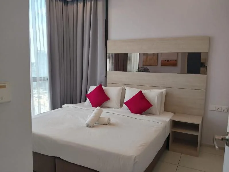 Bedroom features: queen-size bed, upholstered headboard, white bedding, two red accent pillows, nightstand with drawer, floor-to-ceiling windows, sheer curtains, tile flooring, wall-mounted fan, decorative wall art; style: modern; view: city.