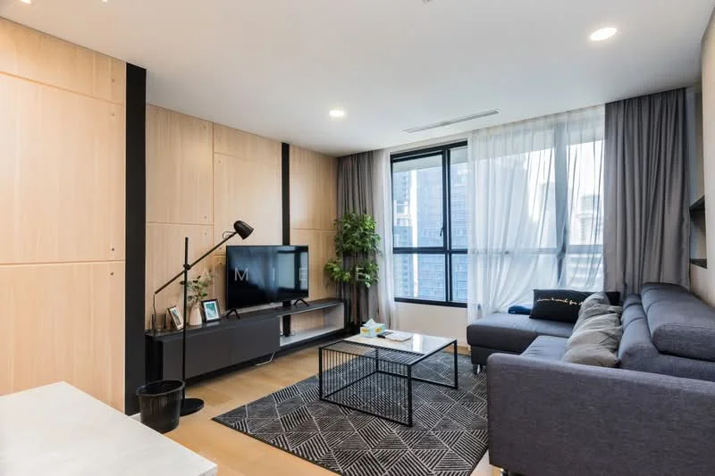 Living features: grey fabric sectional sofa, black coffee table with geometric design, black TV console, wall-mounted TV, floor lamp with adjustable arm, large window with sheer curtains, wood panel feature wall, decorative houseplant, area rug with geometric pattern, light wood flooring; style: modern; view: city.