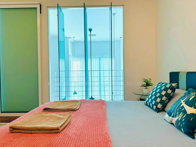 Bedroom features: king-size bed, upholstered headboard, decorative pillows, bedside table, table lamp, light-colored bedding, pink throw blanket, floor-to-ceiling windows, sheer curtains, green accent wall, wooden flooring, indoor plant; style: modern; view: city.