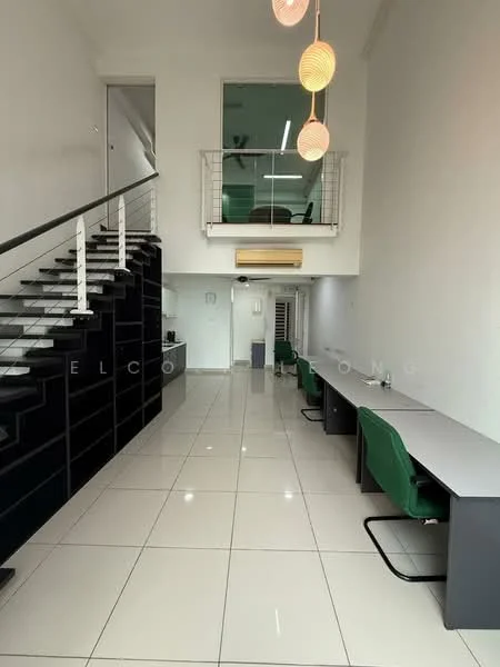 Room features: white painted walls, glossy white tile flooring, staircase with black railing, open space layout, large windows allowing natural light, recessed ceiling lights, 3 pendant lights, 2 work desks with green chairs, air conditioning unit, metal railing on upper level, balcony overlooking the lower level; style: modern.