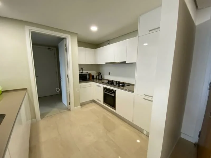 Kitchen features: white cabinetry, stainless-steel built-in oven, stainless-steel gas hob, stainless-steel range hood, black countertop, marble tile flooring, microwave, kitchen sink, refrigerator, modern faucet, under-cabinet lighting, neutral wall color, open layout, doorway to hallway; style: modern.