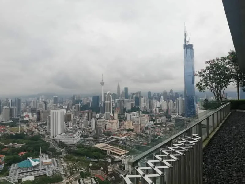Exterior type: high-rise condominium; features: city skyline view, glass railing, landscaped terrace, surrounding urban landscape, modern architecture, visible landmarks including Petronas Twin Towers and Merdeka 118; style: modern.
