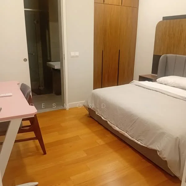 Bedroom features: queen-size bed with grey upholstered headboard, white bedding, wooden flooring, built-in wardrobe with wooden finish, study desk with pink tabletop, wooden chair, wall-mounted light fixture, neutral painted walls; style: modern. Room features: bathroom visible through door, grey tiled flooring in bathroom, white sink, toilet visible.