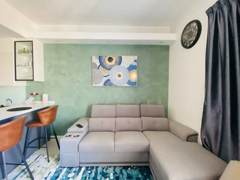Living features: grey fabric sectional sofa, decorative wall clock, green accent wall, abstract artwork, bar counter with high stools, recessed lighting, area rug with geometric pattern, floor-to-ceiling window treatments in dark grey, open shelving with glass-front cabinets; style: modern.