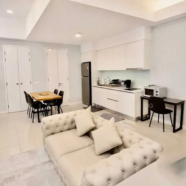 Living features: cream tufted sofa, two decorative cushions, light grey area rug, recessed ceiling lights, white painted walls, tile flooring, open-plan layout, wall-mounted TV, dining table with four chairs, kitchen cabinetry in white, stainless-steel fridge, microwave, kitchen countertop, kitchen sink, kitchen appliances; style: modern.