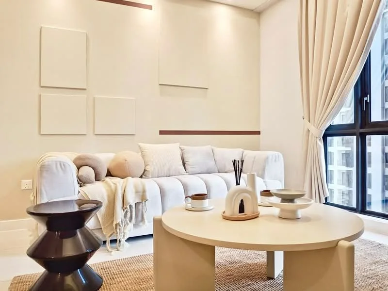 Living features: white fabric sofa, decorative cushions, round coffee table, black side table, woven area rug, floor-to-ceiling windows, sheer curtains, wall-mounted artwork, light-colored walls, recessed downlights; style: modern; view: city.