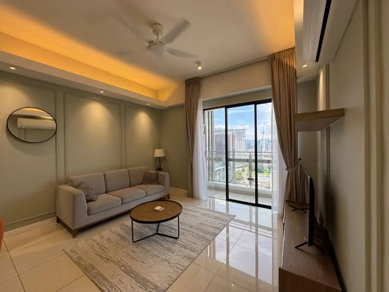 Living features: 3-seater fabric sofa in light grey, round coffee table with wooden top, area rug with geometric pattern, floor-to-ceiling windows, sliding glass door, city view, wall-mounted TV, wooden TV console, ceiling fan with light, recessed downlights, cream painted walls, light-colored flooring with tiles, curtains in light fabric; style: modern; view: city.