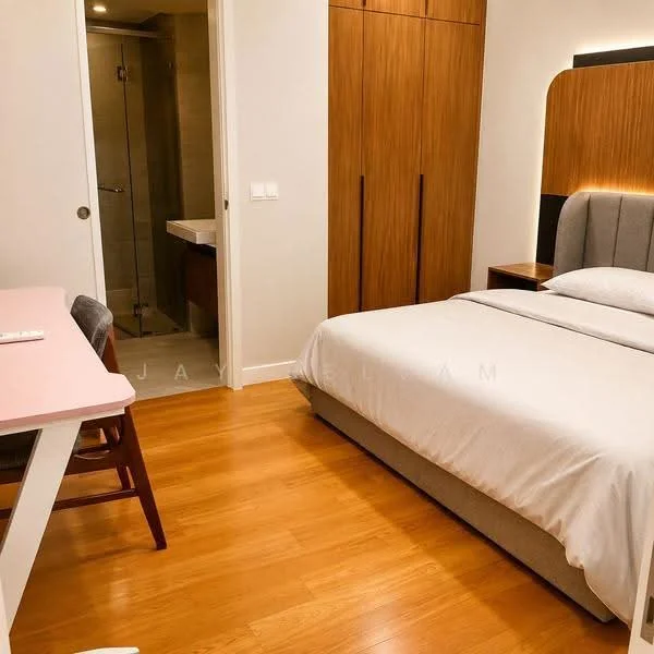 Bedroom features: queen-size bed with upholstered headboard, wooden flooring, built-in wardrobe with wood finish, desk with chair, wall-mounted light fixture, neutral wall color, window with no visible treatment, decorative wall paneling; style: modern.