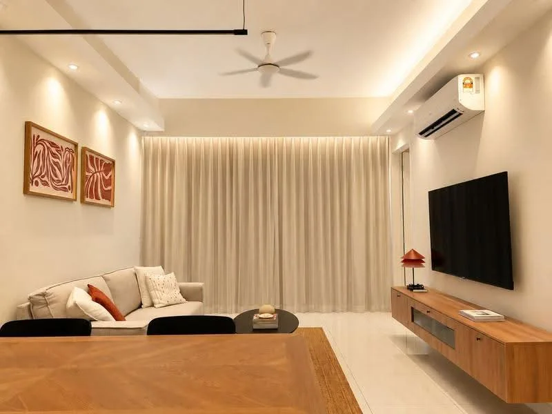 Living features: 3-seater fabric sofa in light grey, coffee table, TV console, wall-mounted TV, 5-blade ceiling fan with light, recessed LED downlights, cream curtains, wooden side table, decorative artwork on walls, air conditioning unit; style: modern.