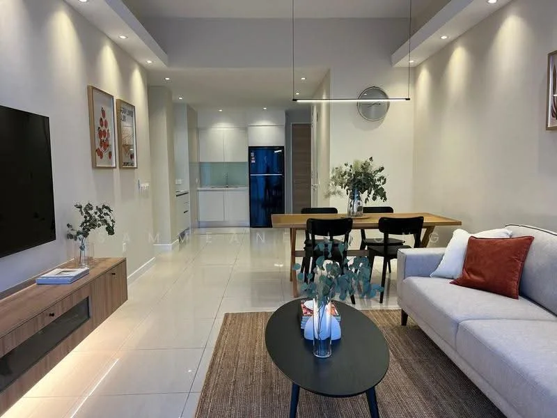 Living features: light grey fabric sofa, red accent pillow, black coffee table, area rug with neutral tones, wall-mounted TV, wooden TV console, decorative vase with flowers, pendant light fixture, recessed downlights, dining table with four black chairs, open kitchen in background, white walls, glossy tile flooring; style: modern. Kitchen features: white cabinetry, stainless-steel fridge, built-in oven, ceramic cooktop, white backsplash, countertop with overhang, open shelving, recessed lighting; style: modern.