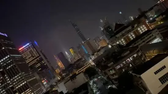 Exterior features: city skyline, night view, illuminated buildings, high-rise structures, urban landscape; style: modern.