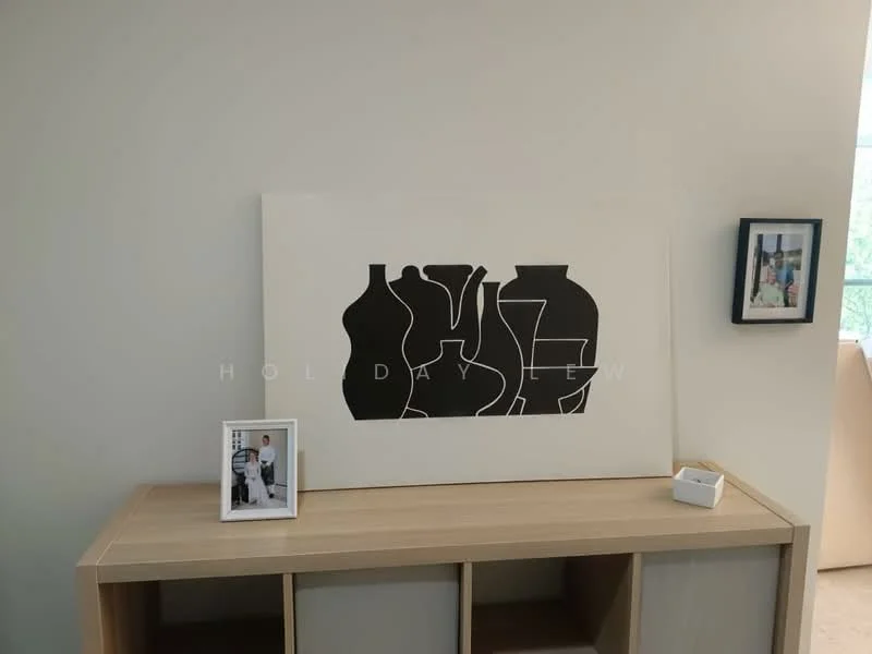 Room features: light-colored walls, wooden console table, abstract artwork on wall, framed photographs, decorative box; style: modern.