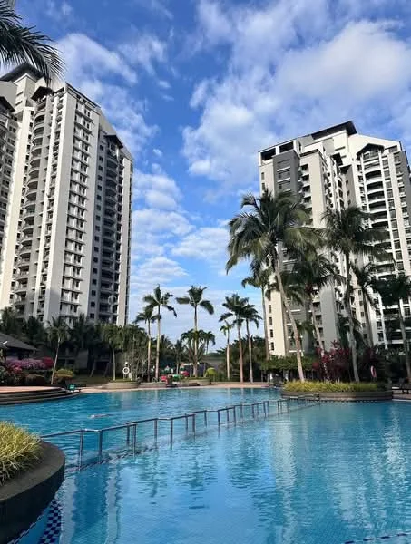 Exterior type: high-rise condominium; features: two high-rise buildings, infinity pool, palm trees, manicured landscaping, blue sky with clouds, pool deck with loungers, outdoor seating area, lush greenery; style: modern.