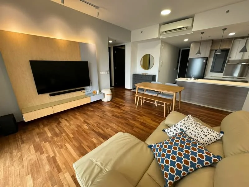 Living features: light brown wooden flooring, cream leather sofa, decorative cushions with geometric patterns, wall-mounted flat-screen TV, wooden TV console, round mirror on wall, dining table with wooden finish, 4 dining chairs, recessed ceiling lights, air conditioning unit, open kitchen layout; style: modern.