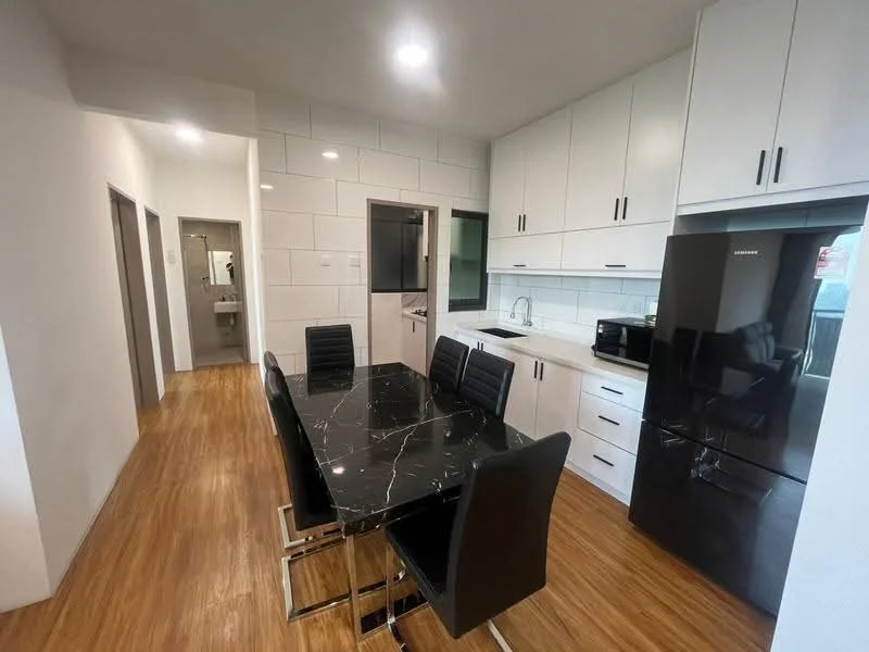 Dining features: black marble dining table, 6 black leather dining chairs, white cabinetry, black refrigerator, built-in microwave, stainless-steel sink, chrome pull-down faucet, white tiled backsplash, wooden flooring, recessed downlights; style: modern. Kitchen features: white cabinetry, black refrigerator, built-in microwave, stainless-steel sink, chrome pull-down faucet, white tiled backsplash, wooden flooring, recessed downlights; style: modern. Room features: white painted walls, wooden flooring, recessed downlights.