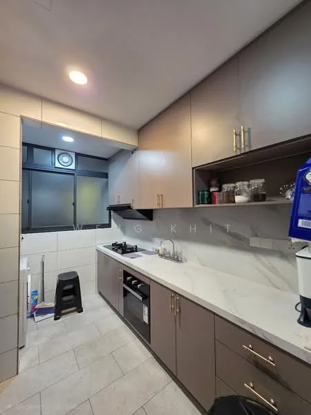 Kitchen features: grey upper cabinets, brown lower cabinets, white marble countertop, stainless-steel sink, chrome pull-down faucet, built-in oven, 4-burner gas hob, exhaust hood, tile backsplash, light grey tile flooring, recessed downlights, window with black frame, stool, kitchen appliances on countertop; style: modern.