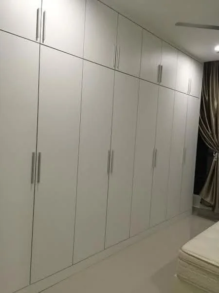 Room features: built-in white cabinetry, multiple cabinet doors, minimalist design, smooth surface, chrome handles, neutral wall colour, glossy floor tiles, curtains in beige or gold, ceiling fan; style: modern.