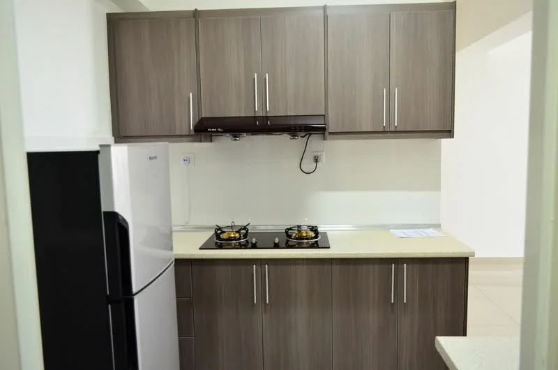 Kitchen features: stainless-steel fridge, built-in gas hob with 2 burners, black range hood, laminate cabinetry in brown, light-colored countertop, white tiled backsplash, wall-mounted electrical outlet, open layout to living area; style: modern.