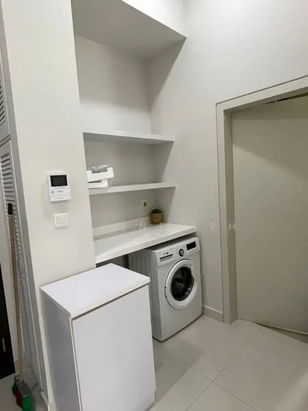Laundry features: white cabinetry, white countertop, front-load washing machine, open shelving, light grey tile flooring, white walls, built-in storage, wall-mounted thermostat; style: modern.