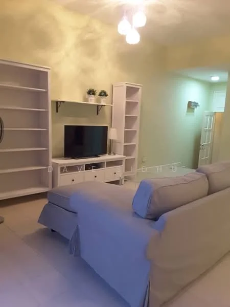 Living features: light green painted walls, white shelving units, white TV console, wall-mounted TV, beige fabric sofa, ceiling lights, tile flooring, decorative plants on shelves; style: modern.
