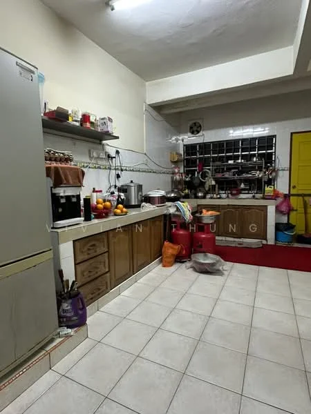 Kitchen features: stainless-steel fridge, wood cabinetry, ceramic tile flooring, white tiled backsplash, double-bowl sink, chrome faucet, countertop with storage underneath, kitchen appliances visible, red area rug, window with grid pattern, wall-mounted shelves, various kitchen utensils and containers.