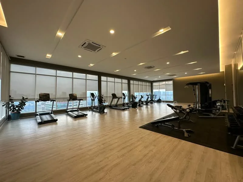 Room features: wooden flooring, large windows with sheer blinds, treadmills, elliptical machine, weight training equipment, exercise mats, ceiling lights, air conditioning unit; style: modern; view: city.