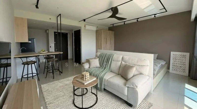 Living features: 3-seater fabric sofa in light beige, coffee table with round top, area rug with geometric pattern, wall-mounted TV, open shelving unit, ceiling fan with light, track lighting, floor-to-ceiling windows, grey accent wall, dining table with two stools, kitchenette with sink, refrigerator, bed visible in background; style: modern; view: city.