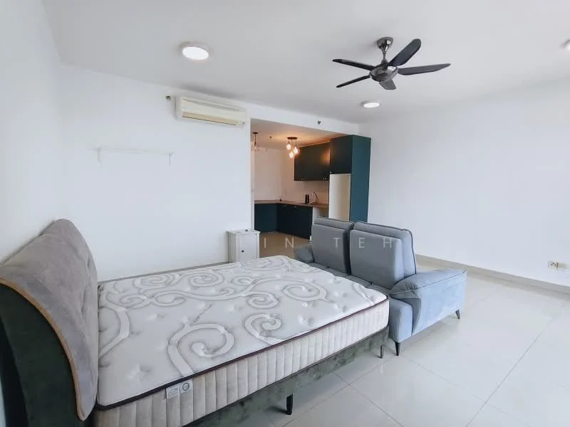 Room features: queen-size bed with mattress, sofa in light blue fabric, ceiling fan, wall-mounted air conditioning unit, white painted walls, tile flooring, recessed downlights, kitchenette visible in background with dark cabinetry, stainless-steel fridge visible, open layout; style: modern.