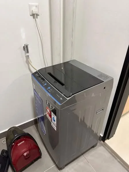 Laundry features: top-loading washing machine in grey, vacuum cleaner in red, electrical outlet on wall, grey tiled flooring, white walls.