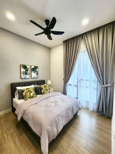 Bedroom features: king-size bed with upholstered headboard, bedding in light purple, two decorative pillows with green and gold patterns, two framed artworks on the wall, floor-to-ceiling windows with sheer curtains, dark grey curtains, wooden flooring, 5-blade ceiling fan, nightstand with lamp; style: modern; view: city.